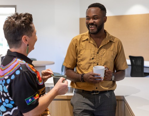 Two people talking and laughing over a cup of tea