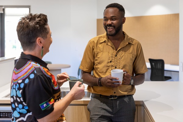 Two people talking and laughing over a cup of tea