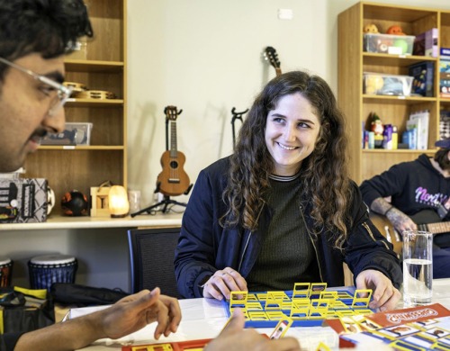 A woman smiling at a friend while they are playing board games
