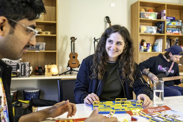 A woman smiling at a friend while they are playing board games