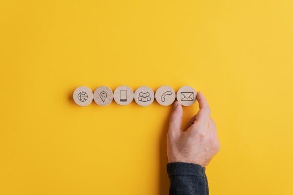 Wooden tiles with icons on each for website, location, mobile, people, landline and email