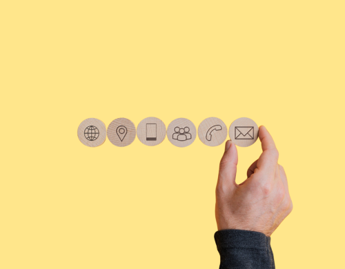 Wooden tiles with icons on each for website, location, mobile, people, landline and email