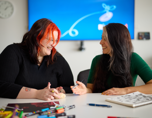 Two people sitting side by side talking and laughing